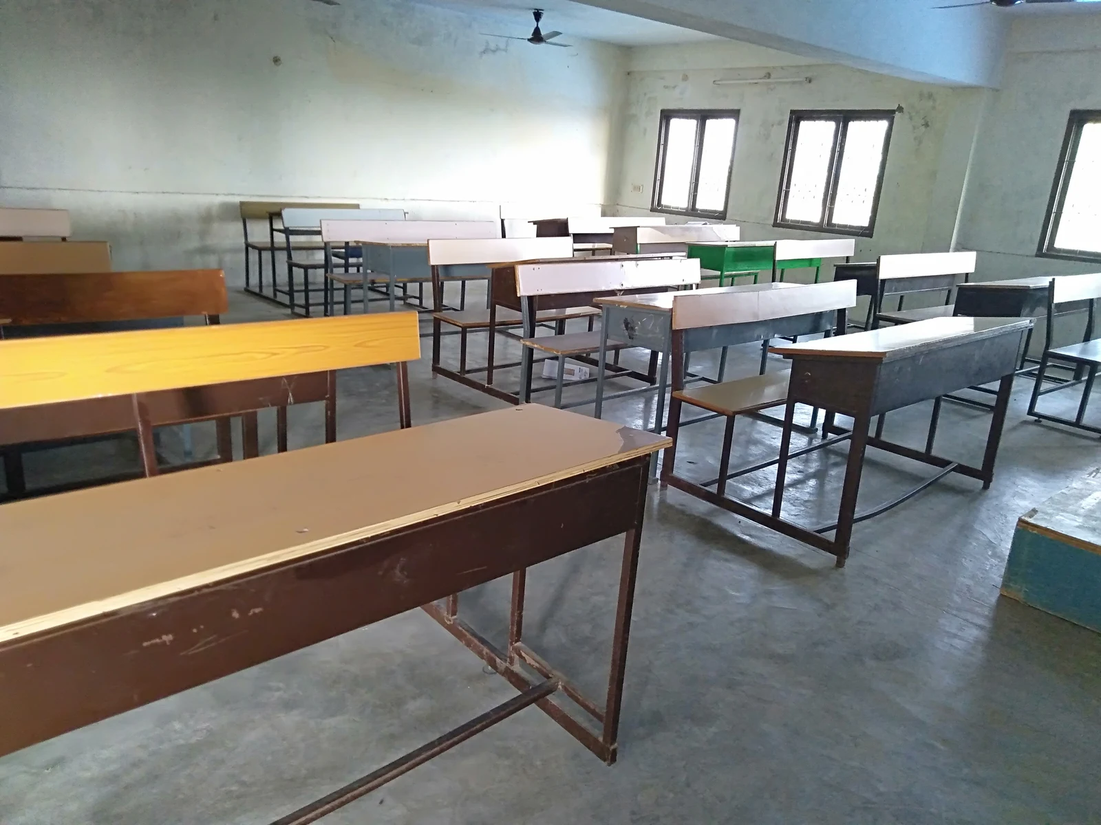 Banchi e sedute di un’aula vuota illuminata dalle finestre